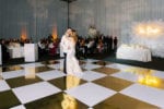 bride and groom dance on their gold and white checkerboard dance floor wrap at jw marriott marquis miami