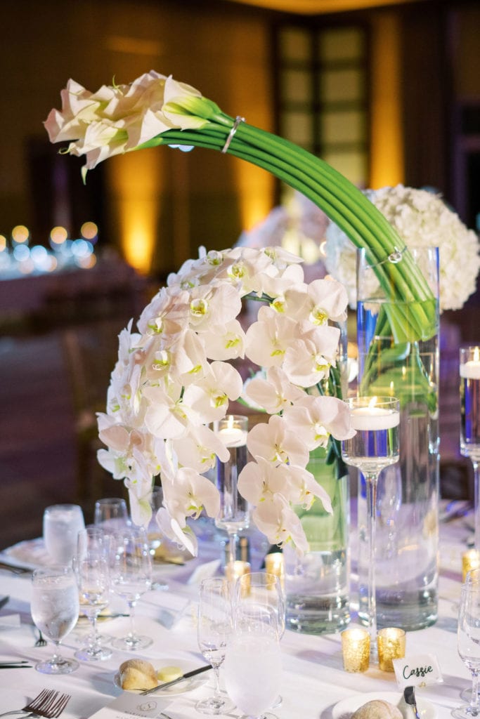 Beautiful table floral centerpiece made of hydrangeas and orchids and decorated with floating candles at The Mandarin Oriental, wedding planned by Oh My Occasions