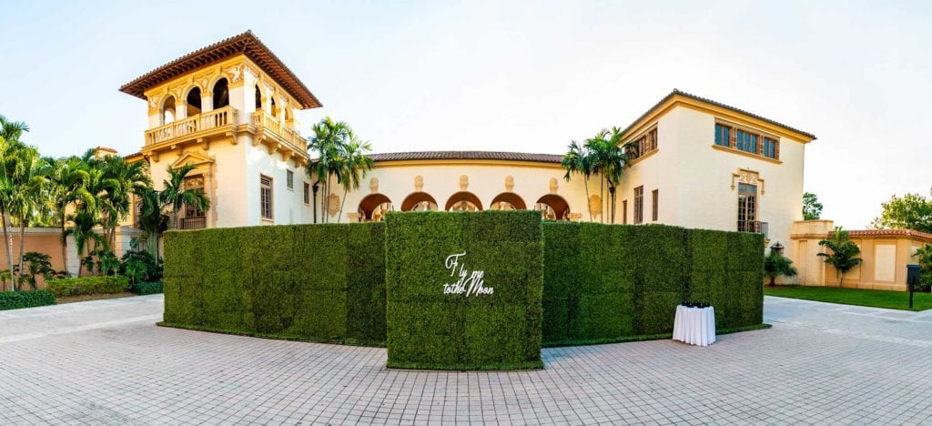 Grass wall with phrase Fly me to the Moon as the ceremony entrance at The Baltimore Hotel in Miami Coral Gables, wedding planned by Oh My Occasions