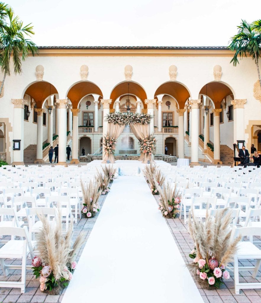 Outdoor ceremony chuppah with pampas grass and champagne draping