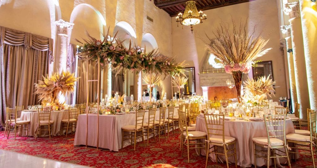 reception tables with pampas grass centerpieces and floral installation.