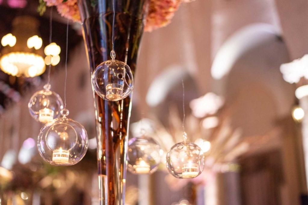 closeup of candles hanging from centerpieces in reception area.