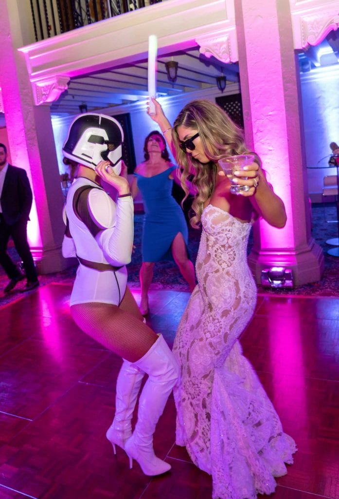 Bride dances with sexy storm trooper holding a drink and glow stick at her reception banquet at The Baltimore Hotel in Miami Coral Gables, wedding planned by Oh My Occasions