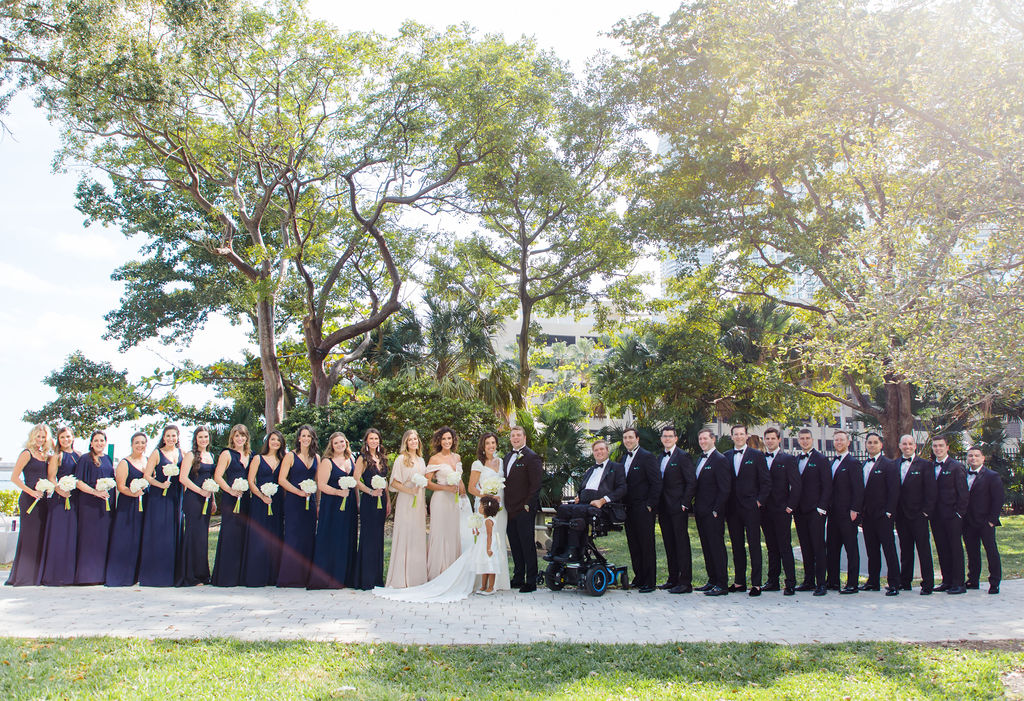 Wedding party stands outside in a straight line with couple in the center, wedding planned by Oh My Occasions 