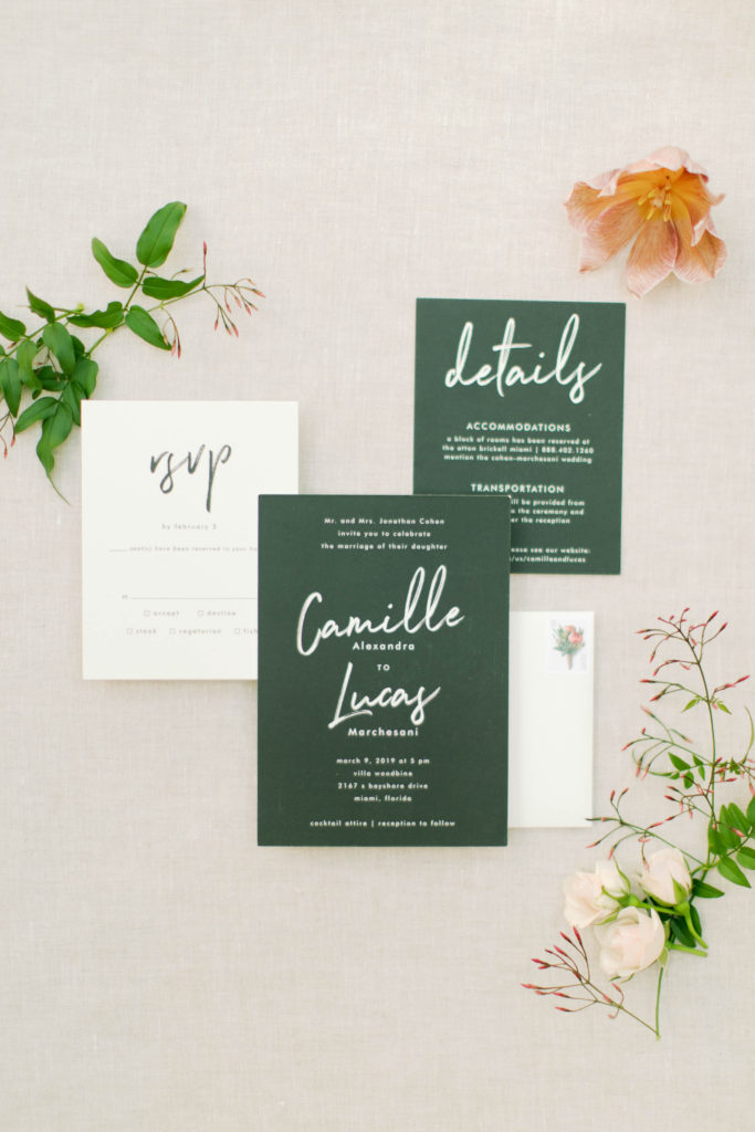 Beautiful layout of the wedding emerald green and white invitation decorated with leaves and flowers at Villa Woodbine in Coconut Grove, wedding planned by Oh My Occasions
