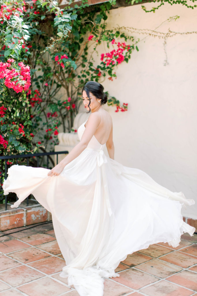 The bride twirling, and showing off her dress at Villa Woodbine in Coconut Grove, wedding planned by Oh My Occasions