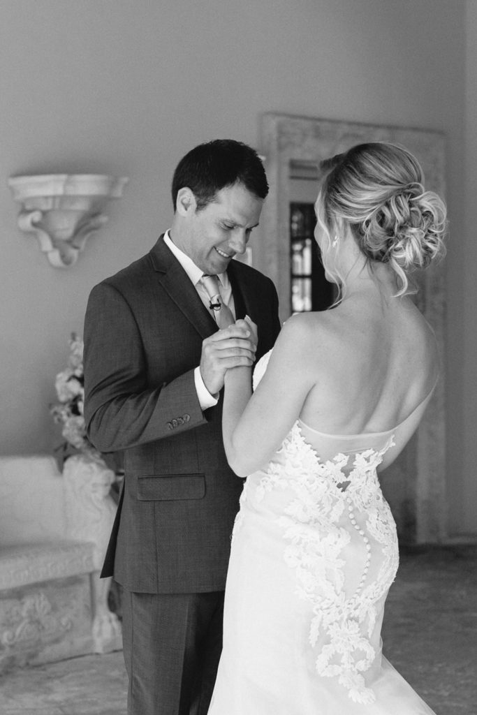 Black and white photo of couple looking towards each other for their first looks.