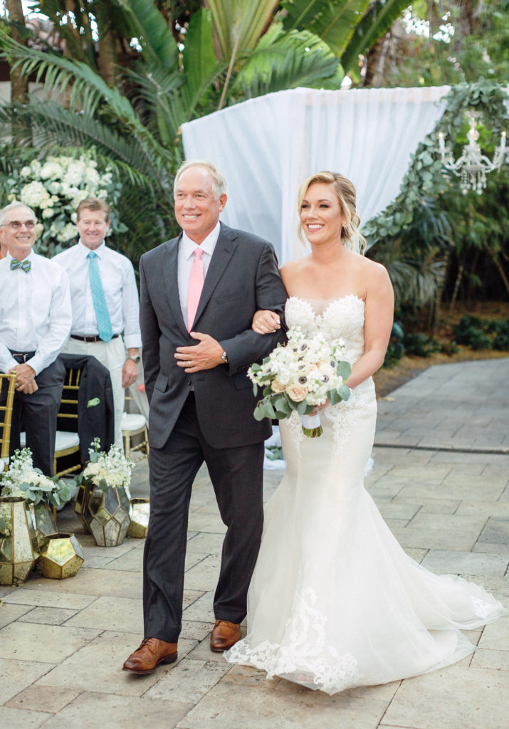 Father of the bride walks his daughter down the aisle in the outdoor ceremony at Fisher Island Club.