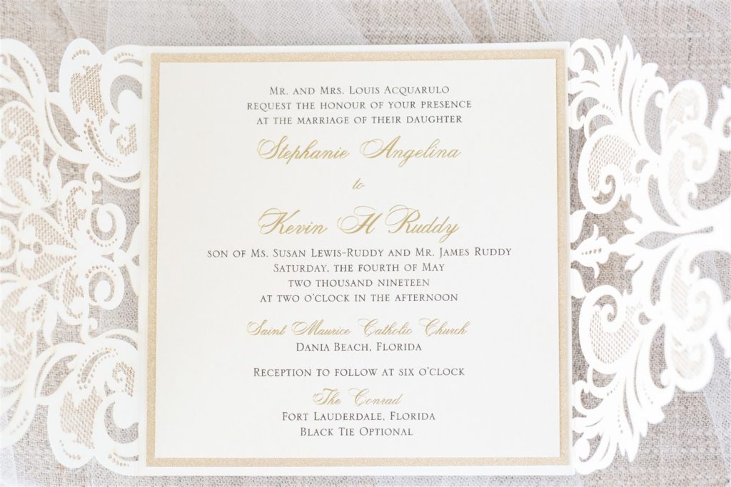 A beautifully laser cut gate fold opened up to delicate gold print and a non-invasive invitation card at The Conrad Fort Lauderdale Beach, wedding planned by Oh My Occasions
