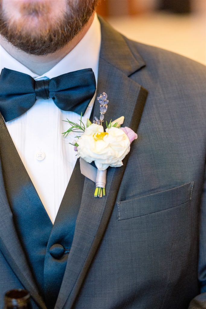A closeup of the groom's white rose boutonniere at The Conrad Fort Lauderdale Beach, wedding planned by Oh My Occasions