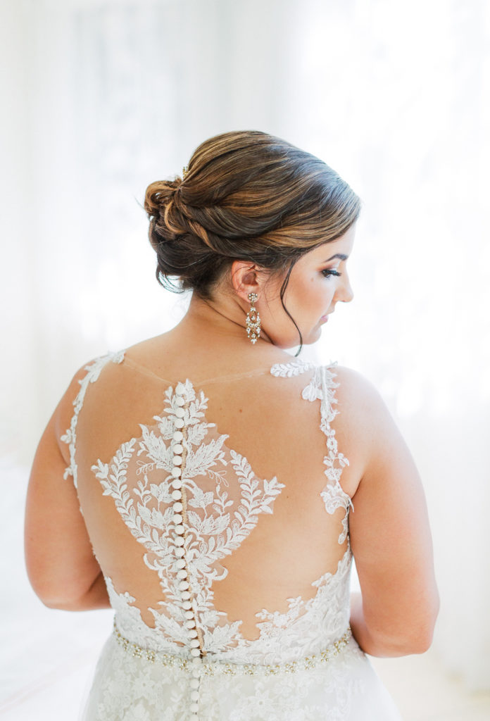 The bride's back of wedding dress shown with lace detailing at The Club of Knights, wedding planned by Oh My Occasions