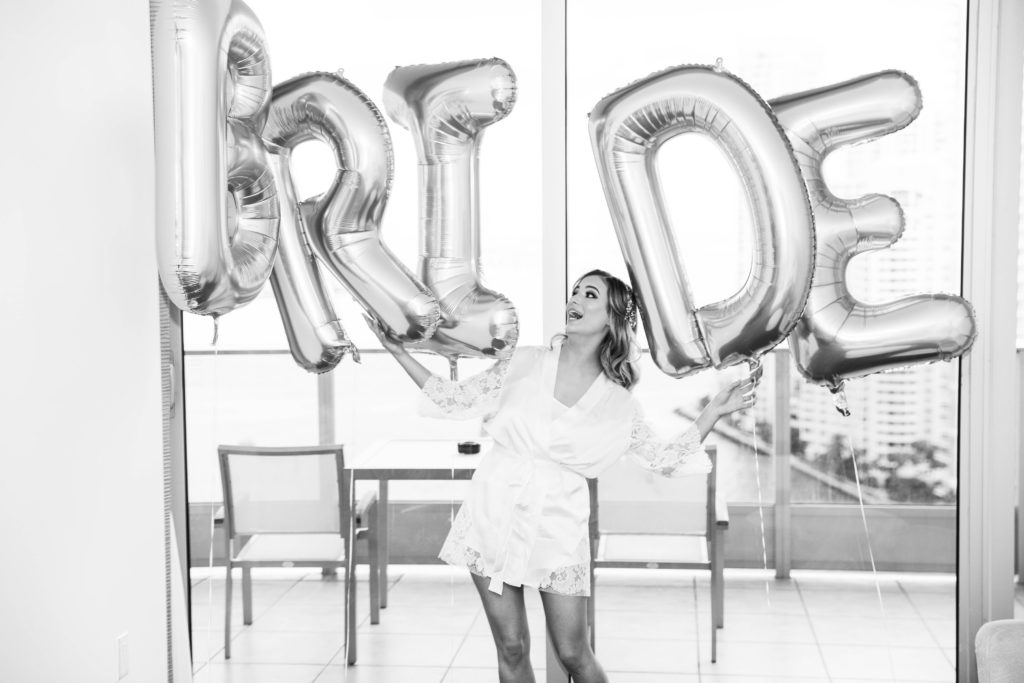 The bride admiring the letter balloons in her getting ready room at the Kimpton EPIC Hotel, planned by Oh My Occasions