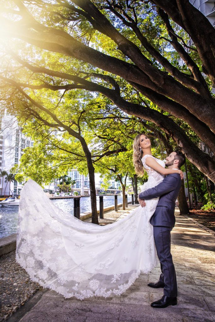 The groom holding the bride up outdoors at the Kimpton EPIC Hotel, planned by Oh My Occasions