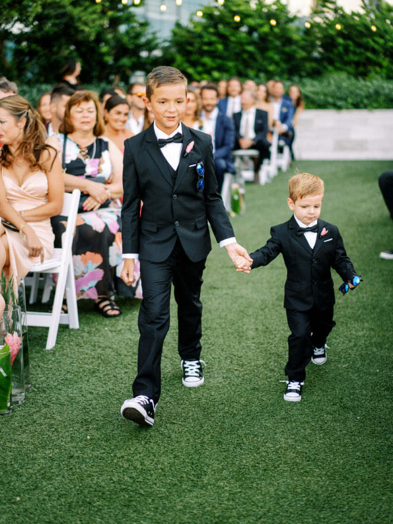 Two adorable ringbearers walking down the aisle at Miami Beach Edition, planned by Oh My Occasions