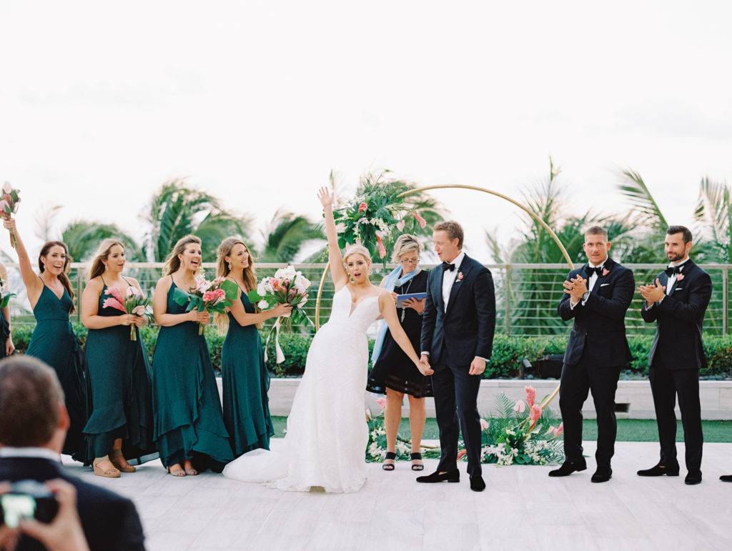 The bride and groom celebrating their ceremony with smiles at the alter outdoors at Miami Beach Edition, planned by Oh My Occasions