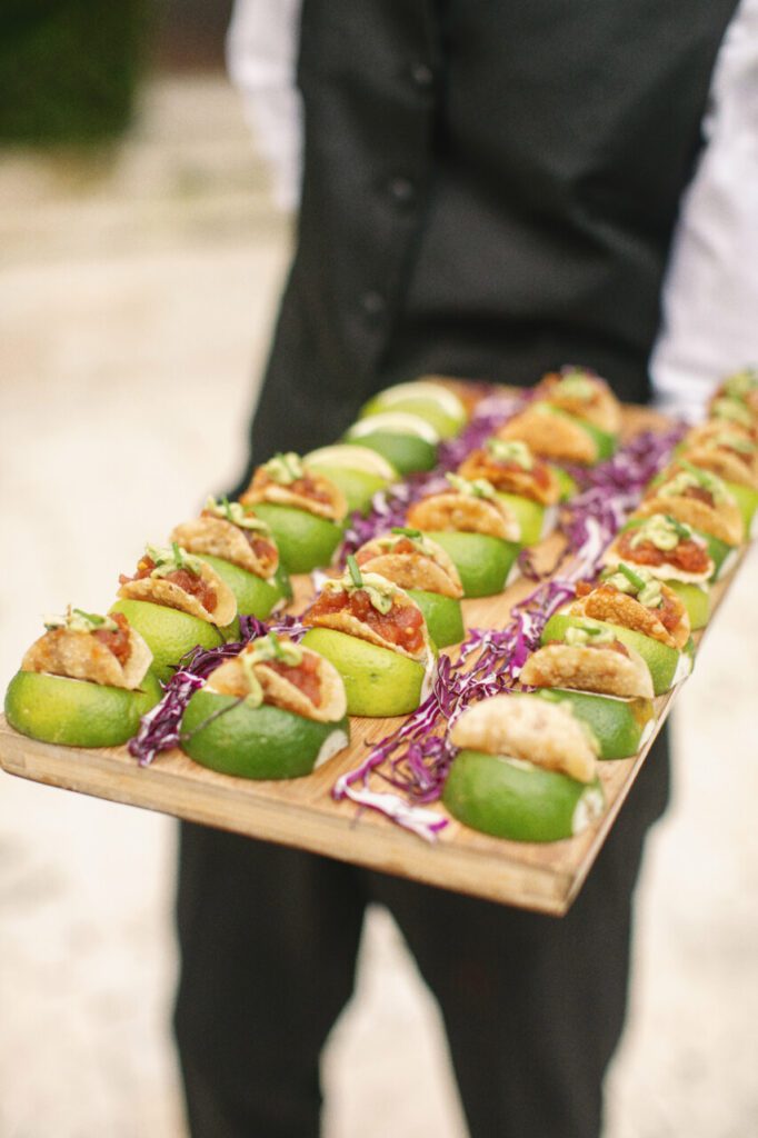 Delicious tuna poke tacos with lime on a wooden tray. The perfect hors d'oeuvres to go around for cocktail hour at Charlotte & Mark's wedding.