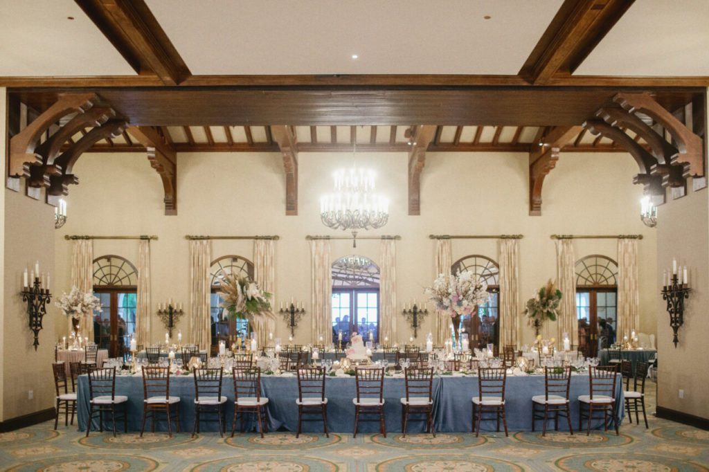 Step back in time with the vintage-inspired wedding venue. A vintage candle chandelier completes the look for a truly romantic atmosphere that will transport you to another era at Indian Creek Country Club planned by Oh My Occasions.