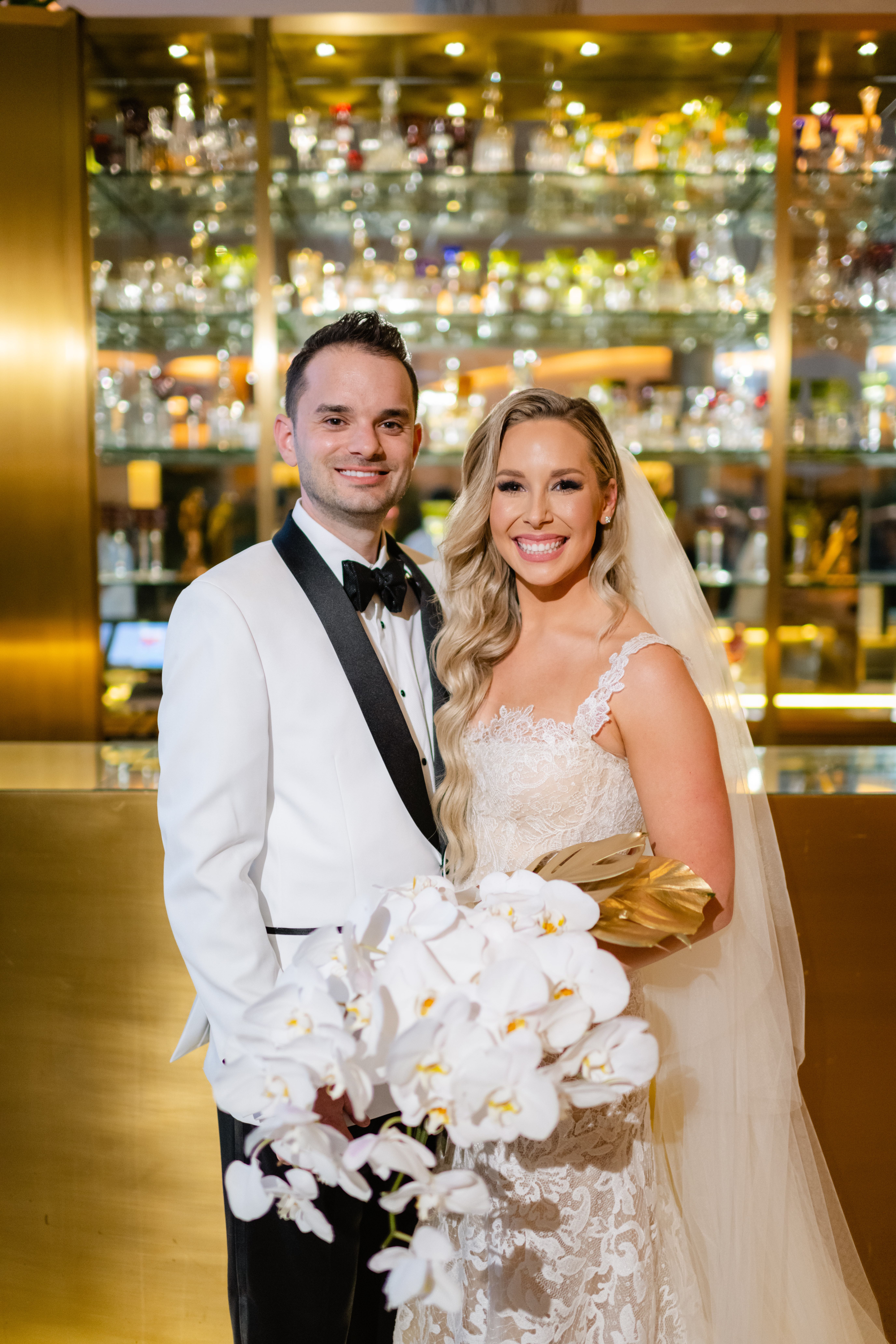The bride and groom smiling together in front of the bar at The Miami Beach Edition, wedding planned by Oh My Occasions