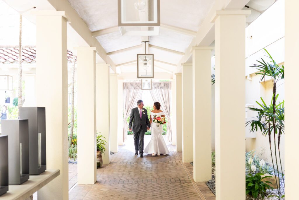 a bride and groom walking through lantern lane at La Playa Golf and Beach Resort in Naples Florida
