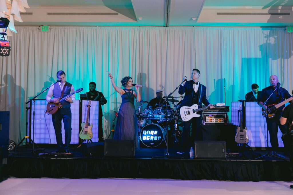 a band singing with a white drape behind them at La Playa Golf and Beach Resort in Naples Florida