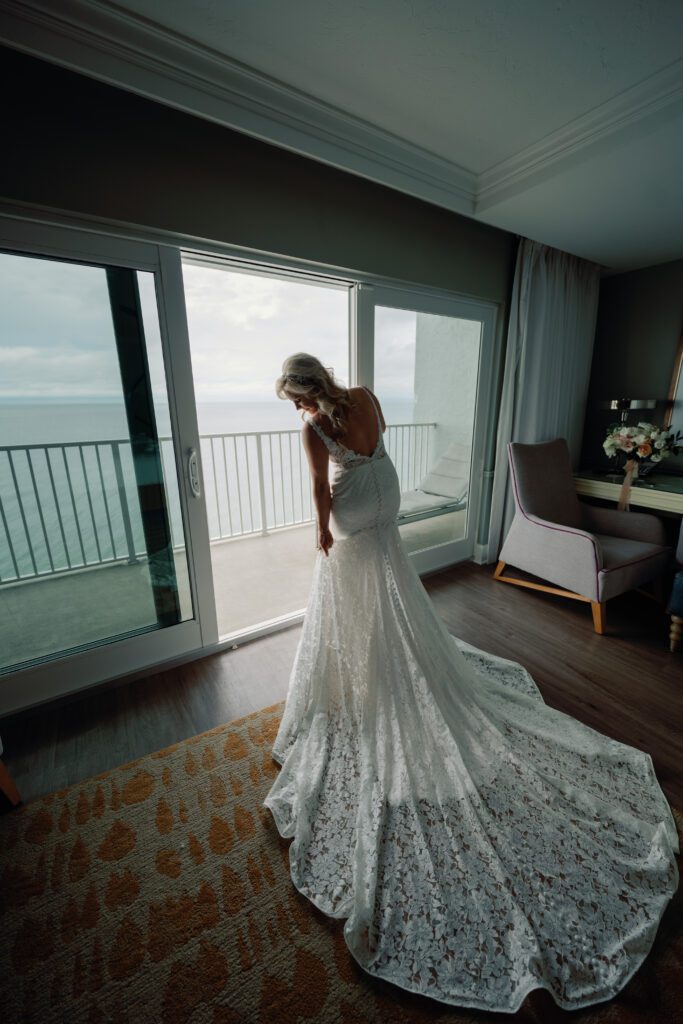 a bride walks out to her balcony at La Playa Golf and Beach Resort in Naples Florida